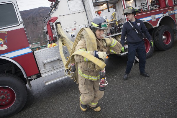 Shift captain Zak Overmeyer supervises as Forrest McDonald runs a fire hose drill during a quiet afternoon at Chugiak Volunteer Fire Department (Photo by Philip Hall / University of Alaska Anchorage).