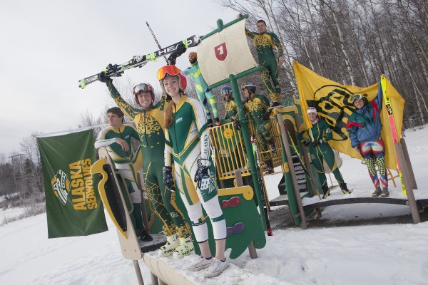 The UAA ski team, dressed in racing suits frmo the past several years, colonize the fittingly green and gold playground at Goose Lake (Photo by Philip Hall / University of Alaska Anchorage).