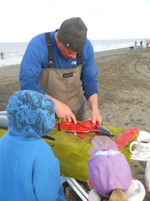 Mike Mueller fileting salmon with his children