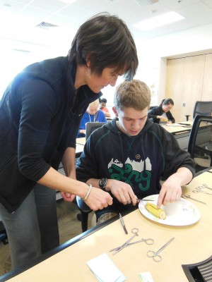 Dr. Tanya Leinecke helps a student suture a banana during last year's Alaska PreMed Summit, at UAA. (Photo courtesy of Alaska WWAMI)