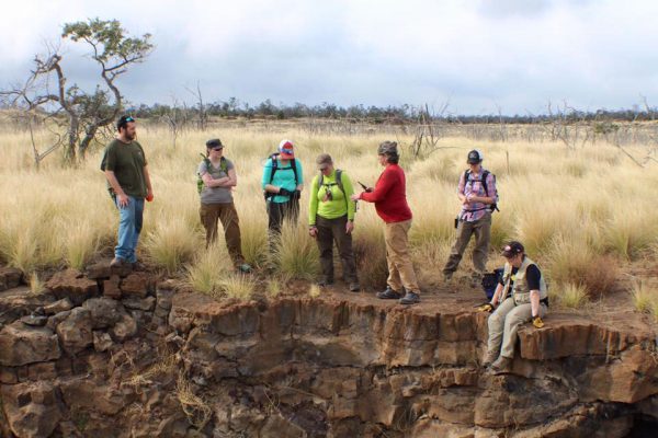 Members of UAA's archaeological team stand before a collapsed sinkhole over a lava tube. (Photo by G. Smith/UAA)