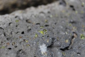 Olivine crystals embedded in the lava flows near the green sand beach (Photo courtesy of Jed Long).