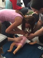 A camper at Mat-Su College's mini med school learns how to perform CPR on an infant mannequin. (Photo courtesy of Kathleen Nevis / Mat-Su College)
