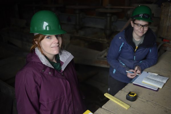 Danielle Chilson, left, and Sydney Deusenberry take measurements inside the mill at Gold Cord Mine, at Hatcher Pass, during a field school in historical archaeology. (Photo by Tracy Kalytiak / UAA)