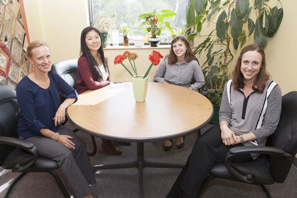 Hattie Harvey, left, and Kathryn Ohle, right, are UAA education professors mentoring UAA students Nina Lee and Sophie Leshan in research projects investigating inconsistencies in the ways teachers determine whether a child is ready for kindergarten and learning how bilingual children's books can foster literacy and language development. (Photo by Philip Hall / University of Alaska Anchorage)