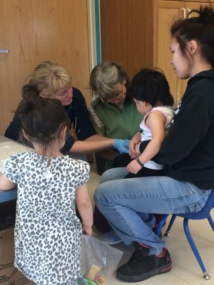 UAA Professor Elizabeth Driscoll and Lisa Zatz, a UAA student who has graduated, examine a child at a rural Head Start. UAA students get real-world experience through Project PAK's outreach to rural Alaska villages. (Photo by Lisa Jackson)