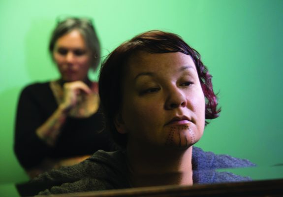 Holly takes a first look at her traditional Inuit tattoo, as artist Maya Sialuk Jacobsen waits in the background, in this 2015 photo (Photo by Michael Conti / Anchorage Museum).