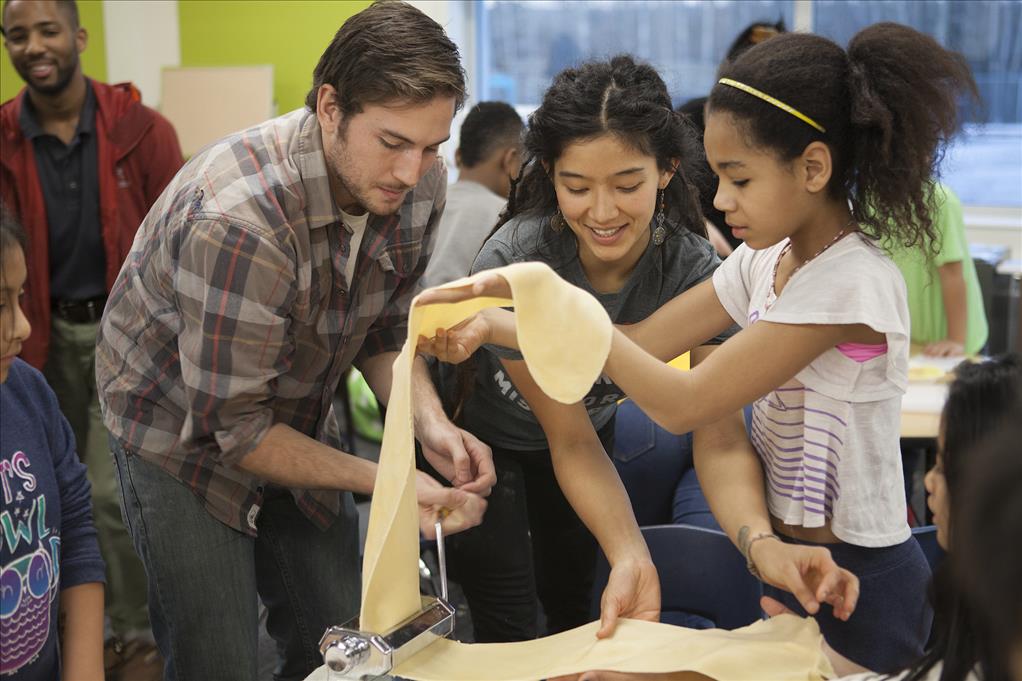 Kipp Wilkinson and Caitlin Alonzo help students make ravioli during a program at Mountain View Elementary School in Anchorage, Alaska Wednesday, Nov. 16, 2016. The program was part of a class project for a University of Alaska Anchorage philosophy course on food justice.