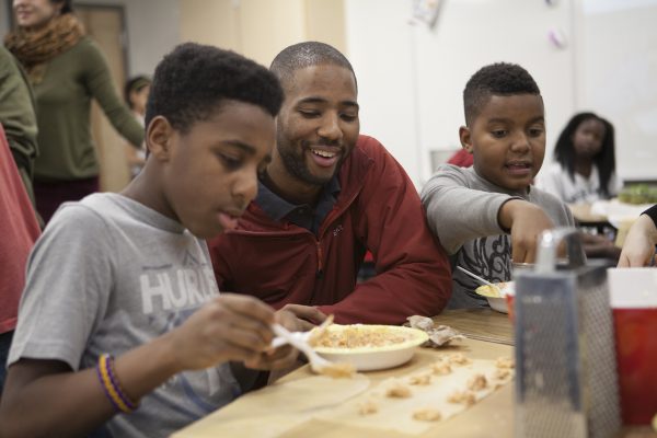  Political science major Demry Mebane helps students make ravioli at Mountain View Elementary School (Photo by Philip Hall / University of Alaska Anchorage).