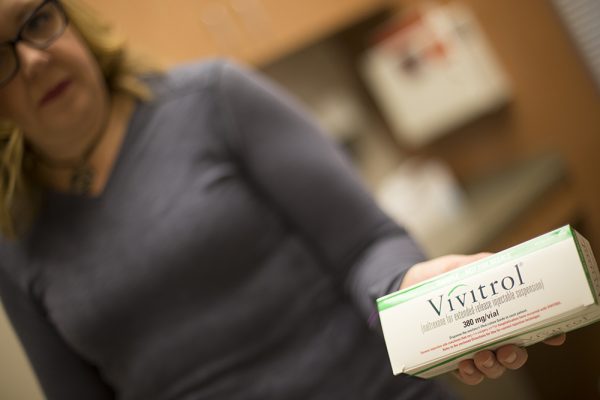 UAA DNP alumna JJyll Green holds a box containing vivitrol. (Photo by Theodore Kincaid / University of Alaska Anchorage)