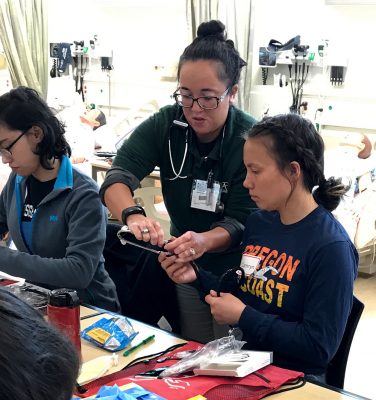 Camryn LeClair, right, gets tips about assembling a stethoscope. Camryn is an East High graduate who recently participated in RRANN's weeklong camp. (Photo by Tracy Kalytiak / University of Alaska Anchorage)