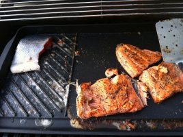 UAA's Dr. Qiujie "Angie" Zheng is researching the marketability of wild Alaska salmon in her home country of China. Here, salmon Zheng caught herself in Alaska cooks on a grill. (Photo courtesy of Angie Zheng)