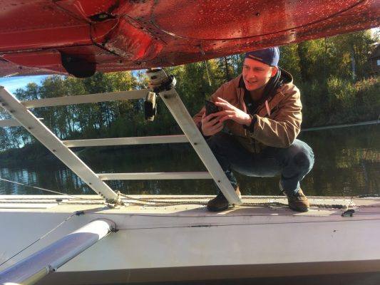 UAA Honors student Devin Boyle installs a GoPro on a float plane as part of his project to better understand how Elodea spreads.