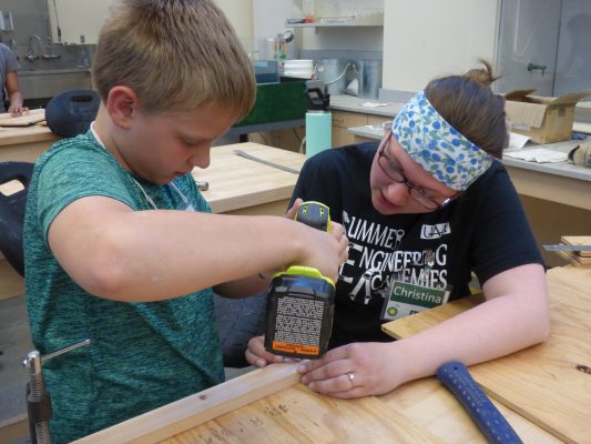 Christina Young assists an aspiring engineer during a UAA Summer Engineering Academies session. (Photo courtesy of UAA College of Engineering)