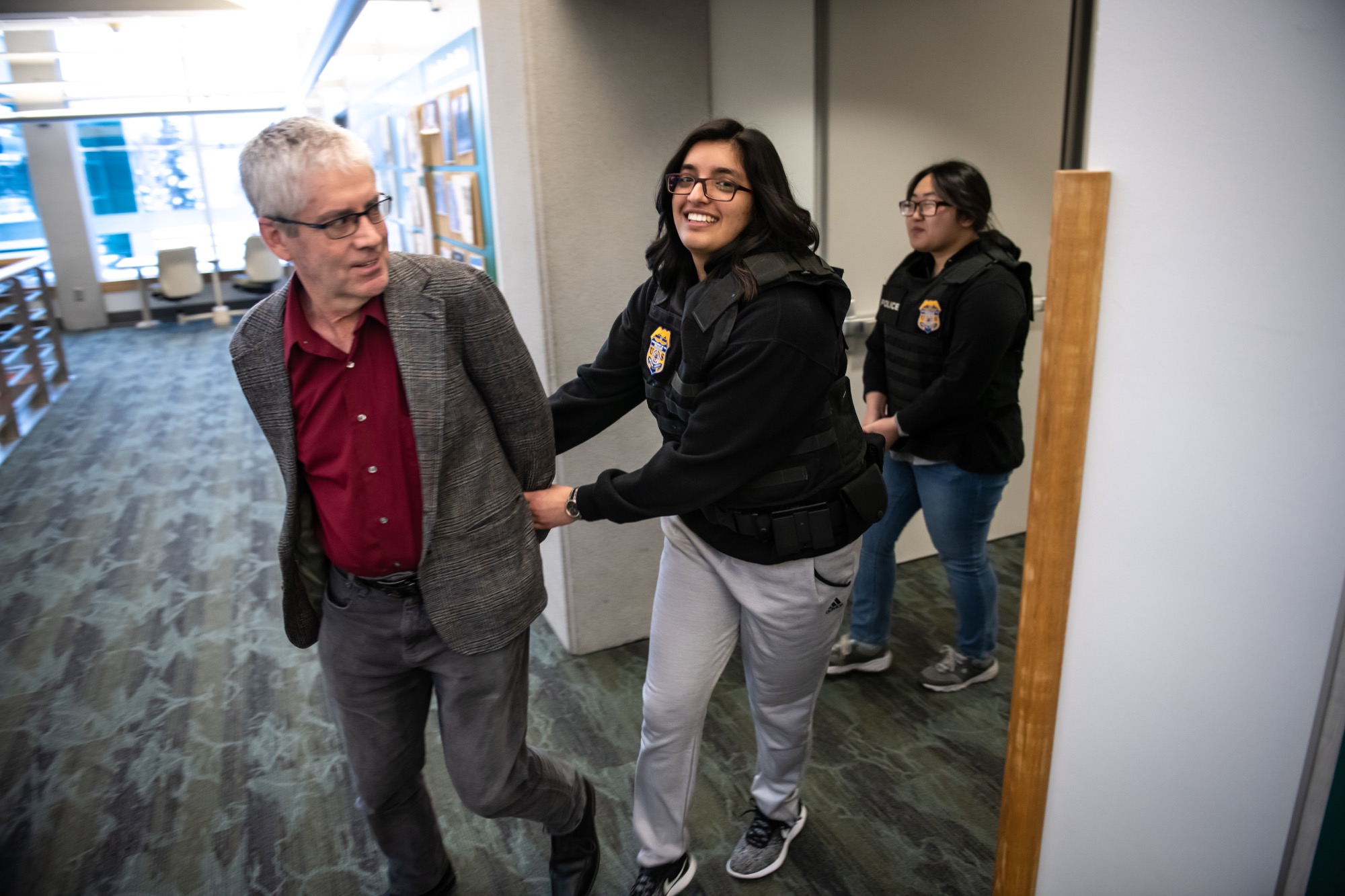 UAA accounting student Meghna Bathija arrests economics professor Paul Johnson as he portrays a white collar criminal during the Adrian Project, a forensic accounting simulation hosted in Rasmuson Hall every other year by the Department of the Treasury's IRS Criminal Investigation (IRS-CI) division. 