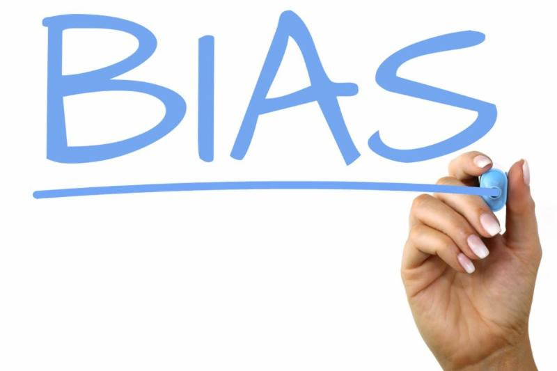 Hand writing out "Bias" on whiteboard