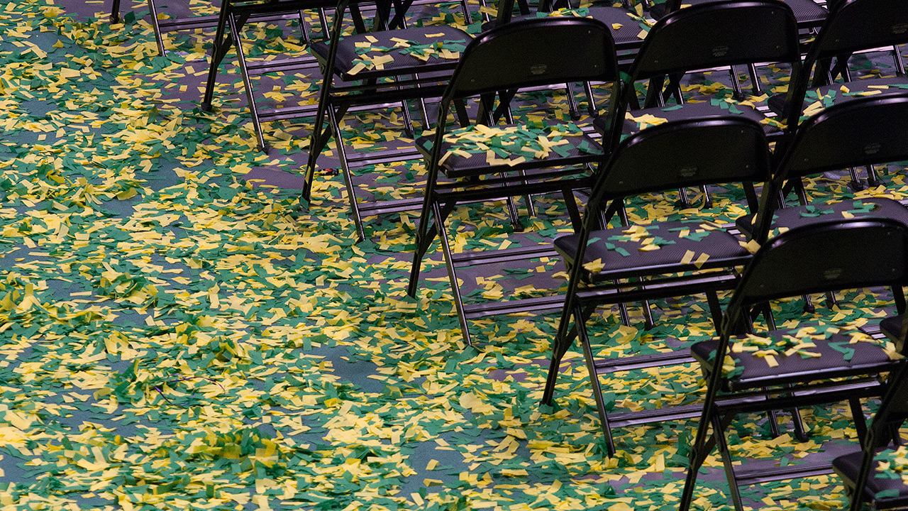 Confetti lines the floor of UAA's Alaska Airlines Center post-commencement