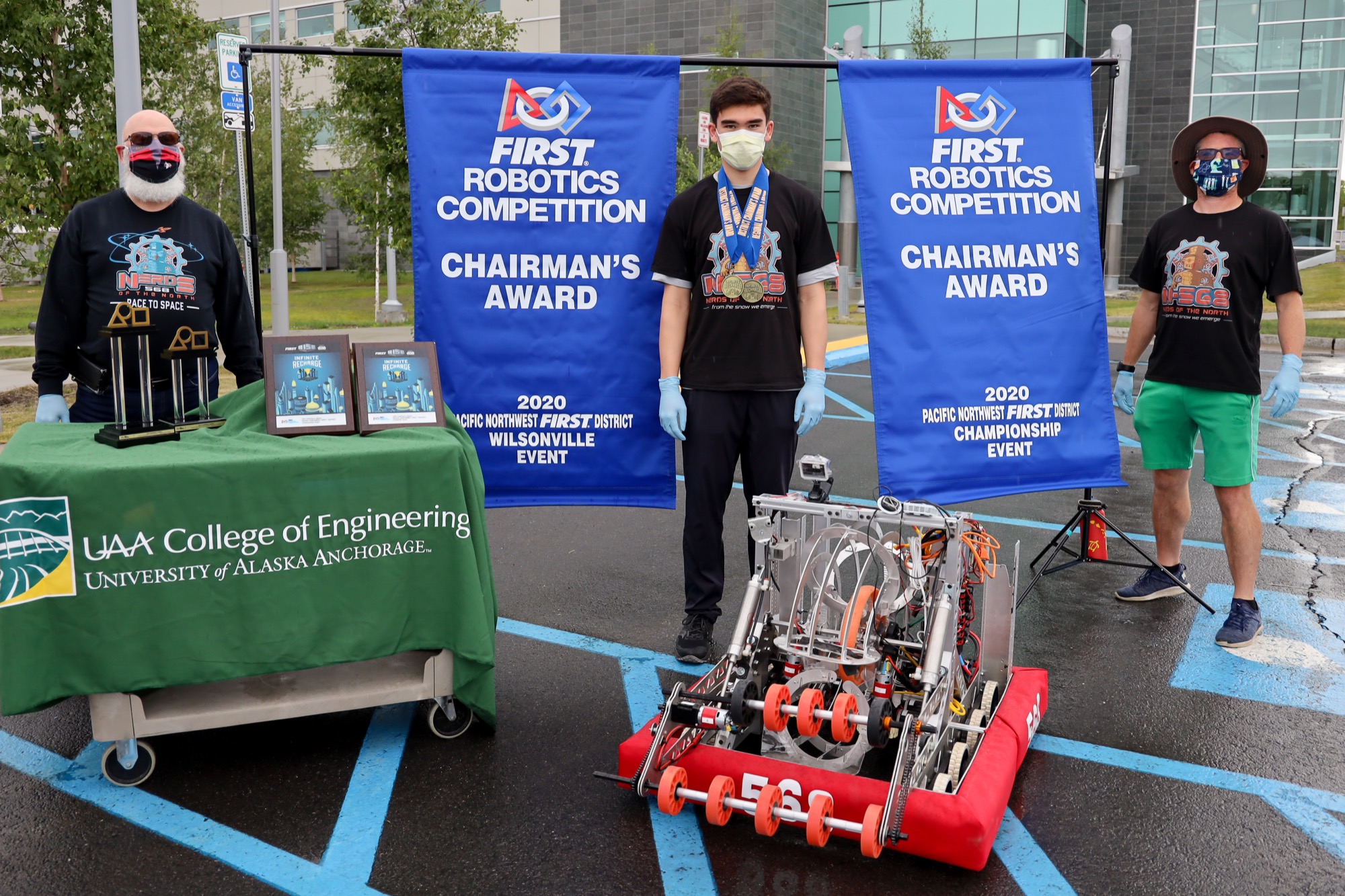 Students from the statewide high school FIRST Robotics Competition team, 568 (FRC 568), accept competition awards from a robot, social-distancing style.