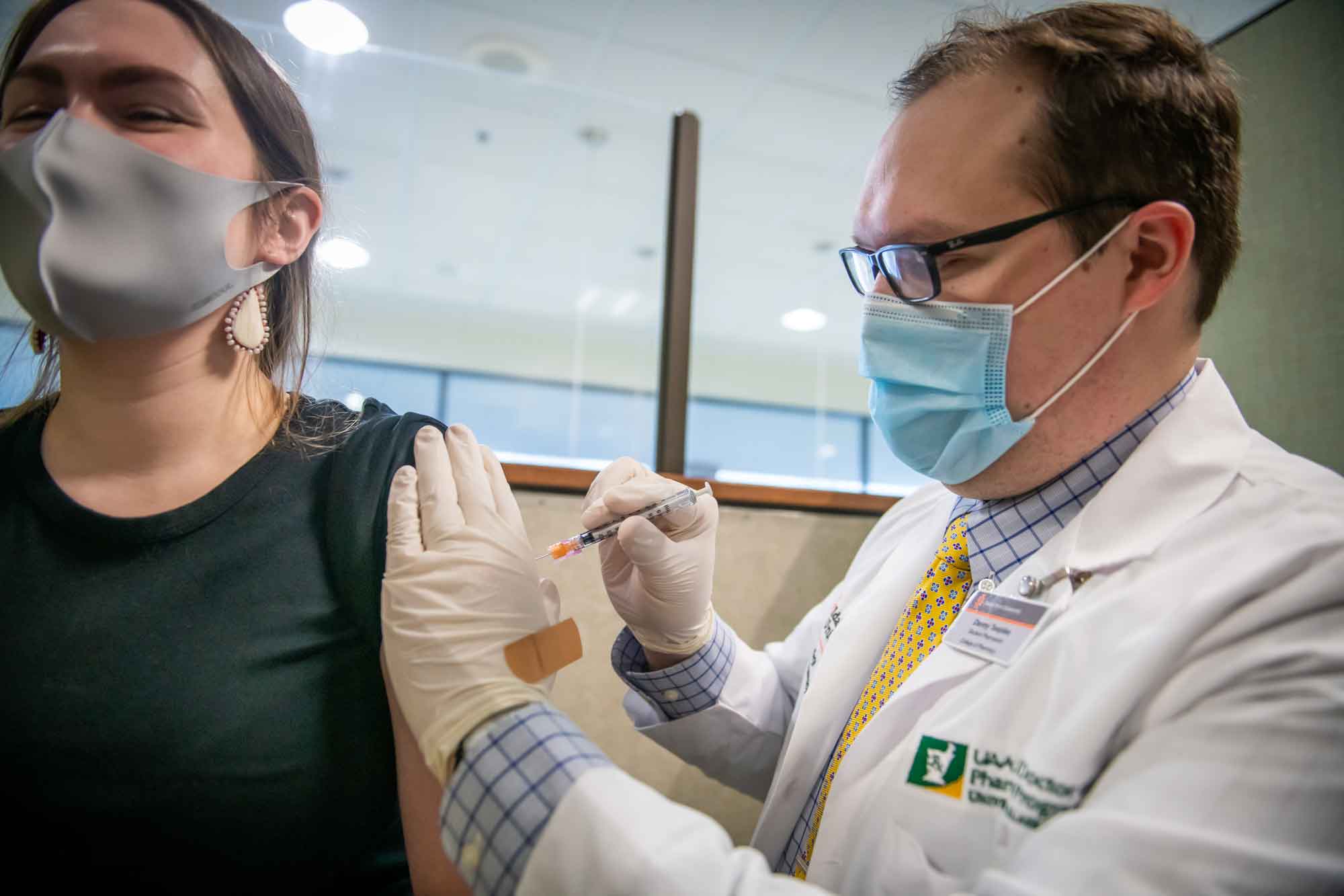 A UAA/ISU Doctor of Pharmacy student administers the COVID-19 vaccine to a healthcare worker. 