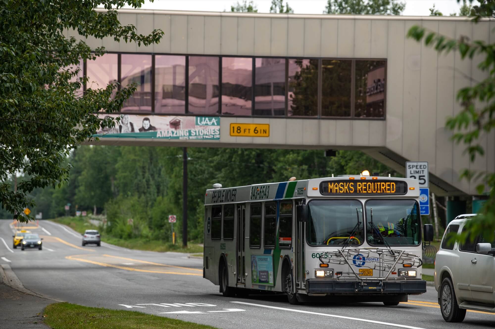 People Mover bus that says 'Masks Required' travels along UAA Drive