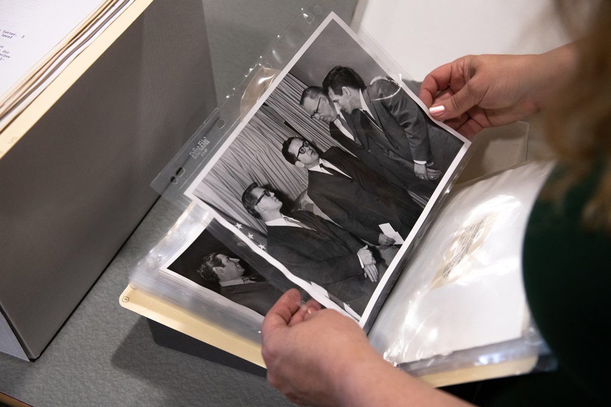 Arlene Schmuland, Head of Archives & Special Collections and Professor of Library Science, looks through photos in boxes of documents from the recently-donated Ted Stevens Alaska Native Claims Settlement Act (ANCSA) papers in UAA's Consortium Library.