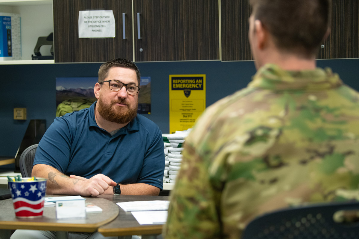 Military and Veterans Benefits Specialist  Greg Benson talks with a military student in UAA's Military & Veterans Student Resource Center in the Student Union.