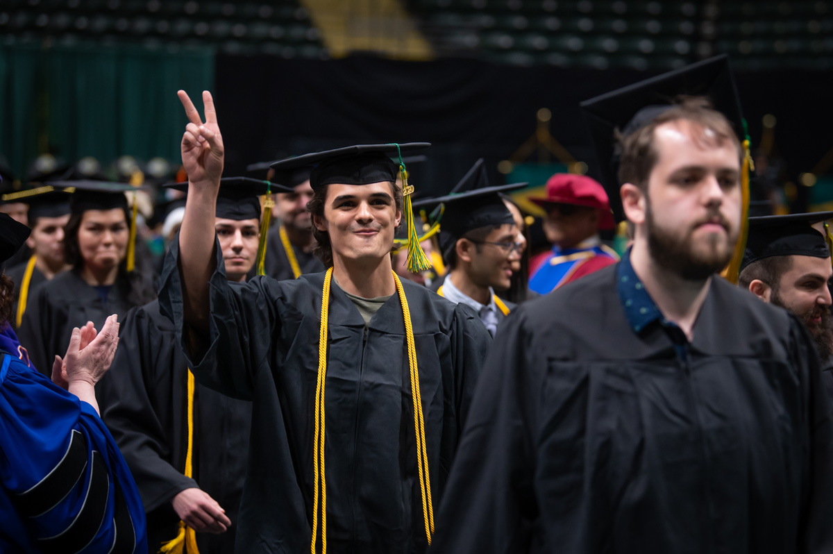 John Gregory, B.S. Natural Sciences, walks through the honor aisle during the UAA reunion commencement. (Photo by James Evans / University of Alaska Anchorage)