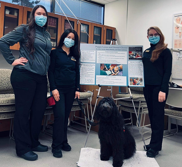 UAA students and therapy dog during research presentation.