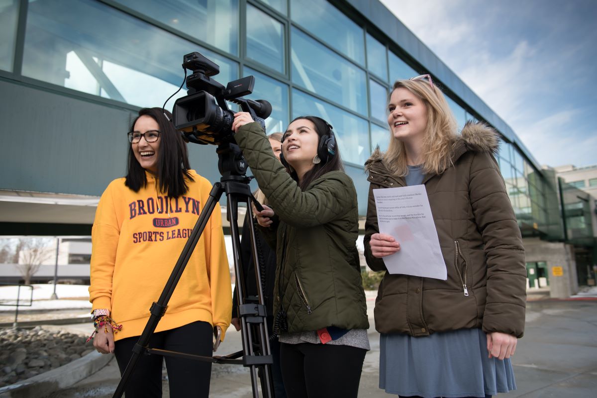 four journalism students using a film camera