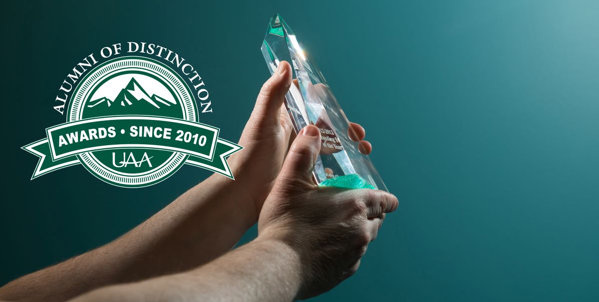 a pair of hands holding an award and a graphic for Alumni of Distinction