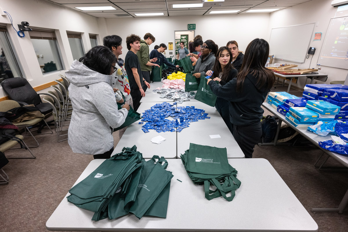Members of UAA's Health Professions Student Organization (HPSO) pack warm wear bags in UAA's Administration and Humanities Building.