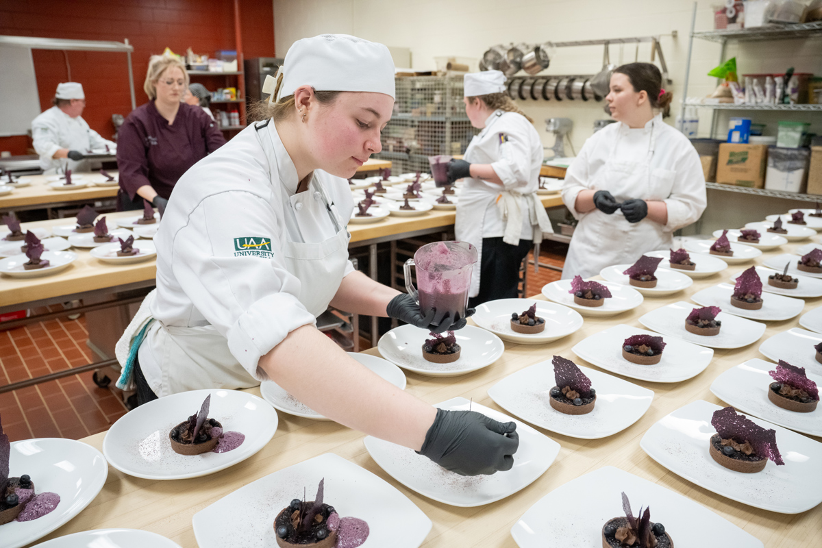Student Paislee Harbour preps the dessert course during UAA's 2024 Celebrity Chef Invitational.
