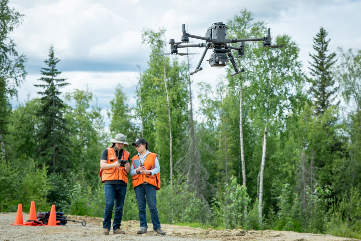 Hoyt Thomas flying a drone as Caixia Wang observes