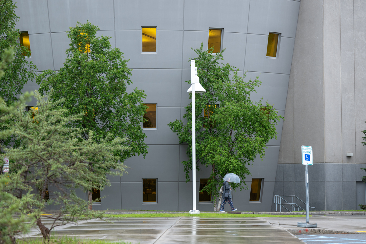 A visitor carries an umbrella on her way into UAA's Consortium Library on a rainy summer morning.