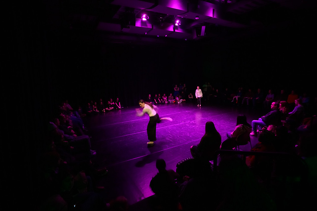 Dancer on stage with crowd in background