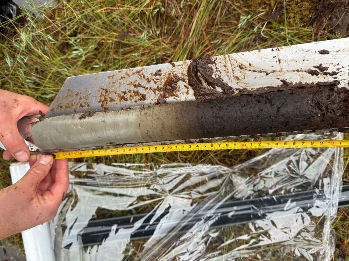 a geologic core sample being measured with a measuring tape