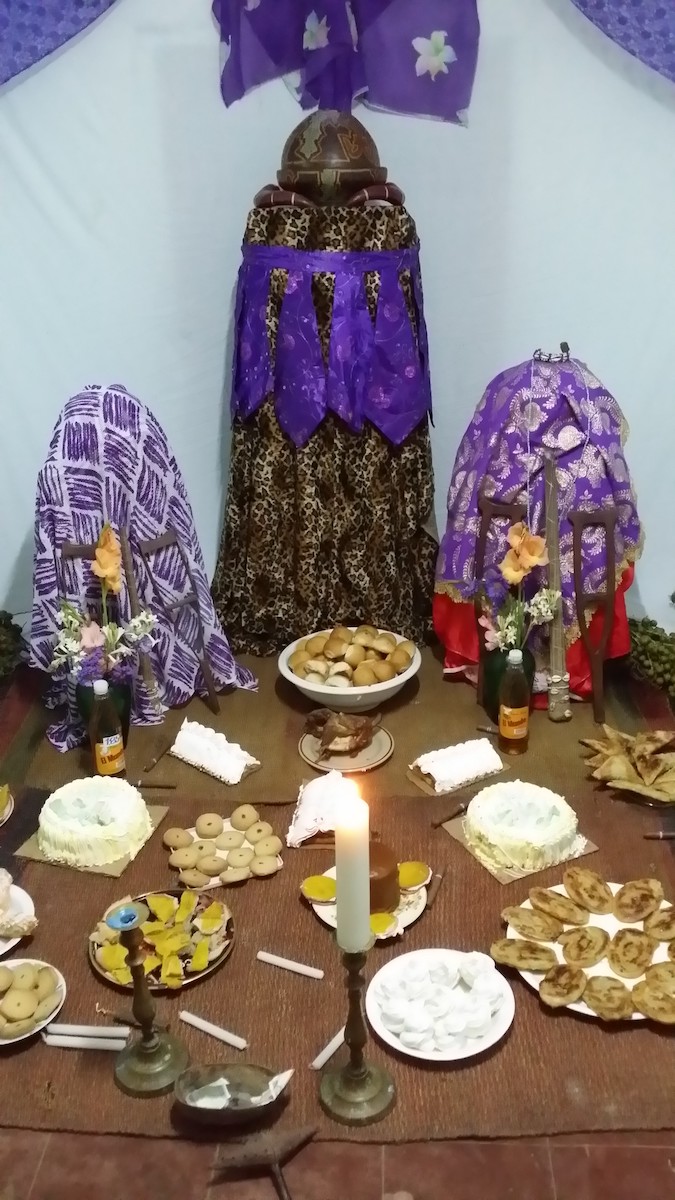 alter for San Lazaro with desserts and candles with purple drapping
