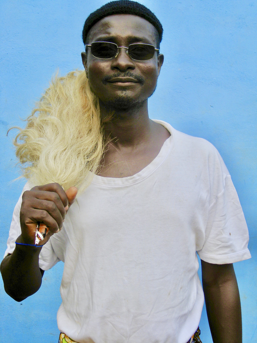 African man in white shirt with a blue wall