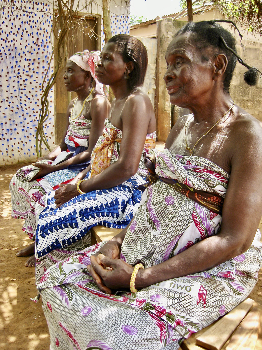 Three African women, hands folded in their laps