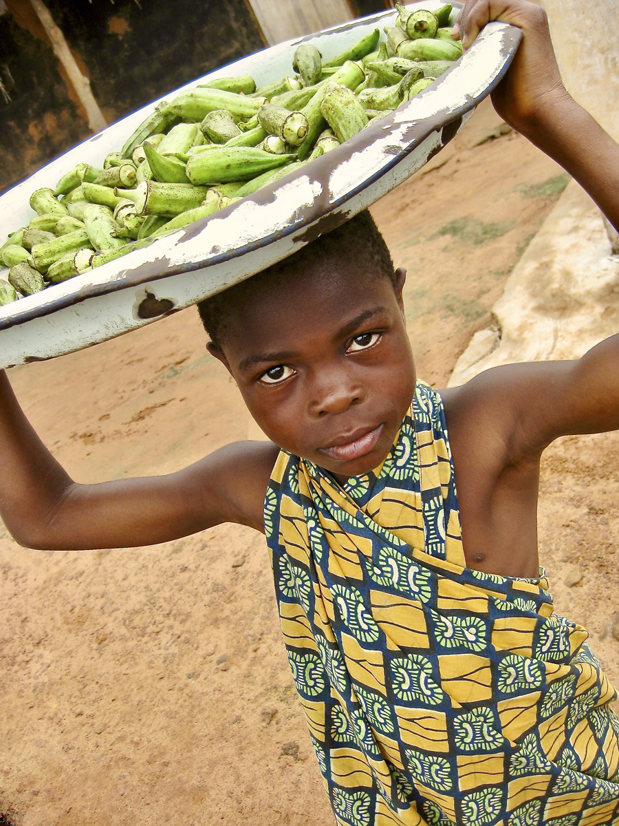 Child with plate and veggies on their head