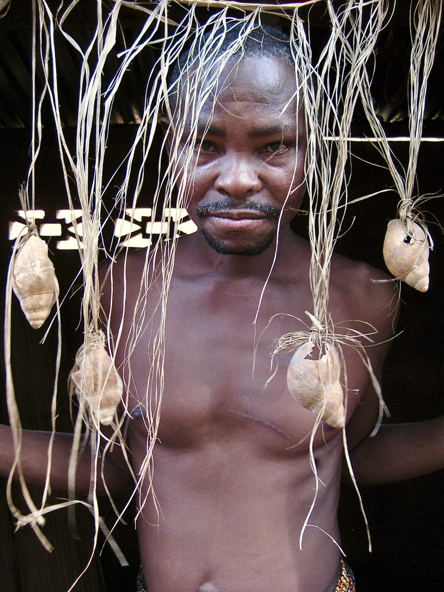 Man standing behind grass and shells