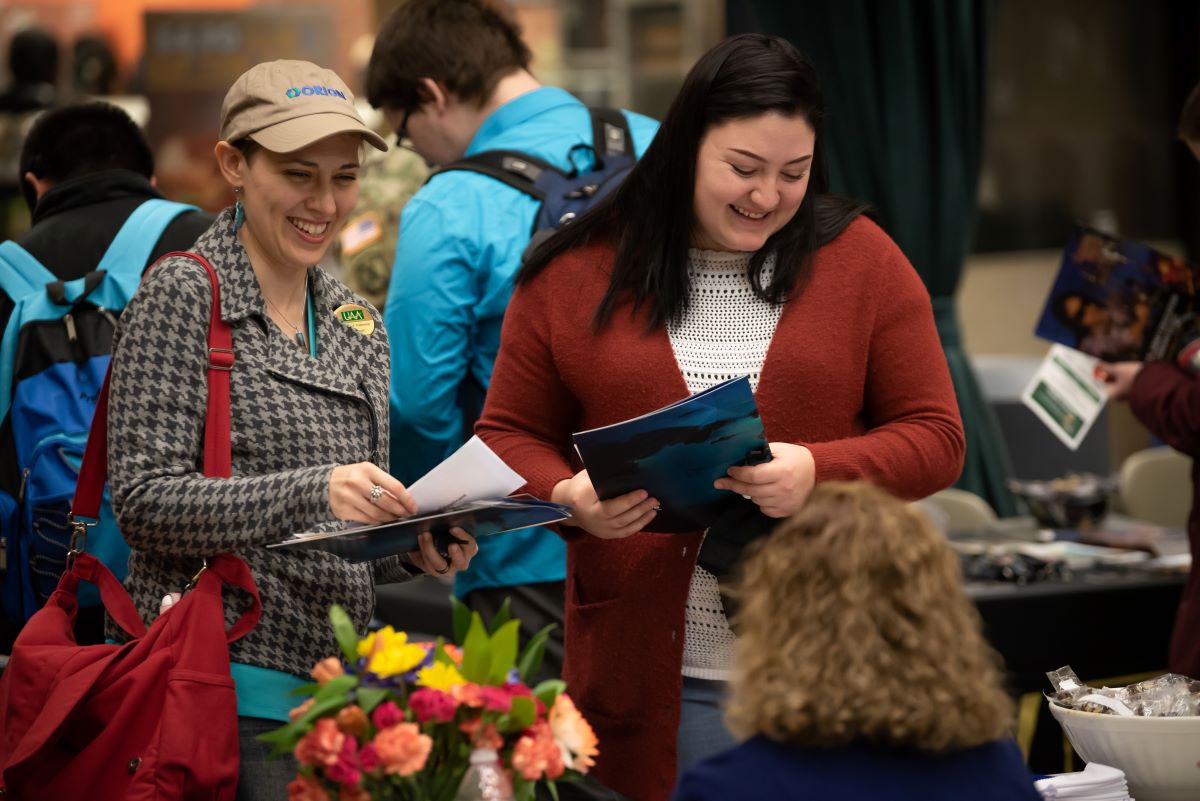 students at a table taking flyers