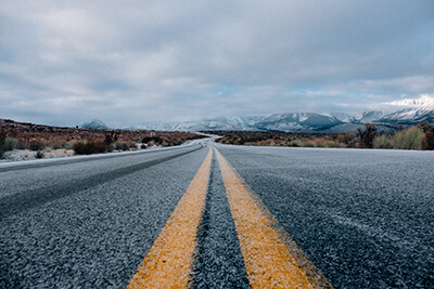 Snow-dusted road stretches off into the mountains.